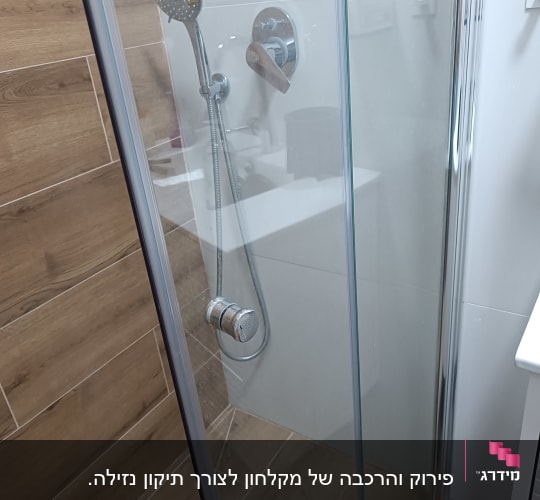 מקלחת עם ראש מקלחת ודלת זכוכית